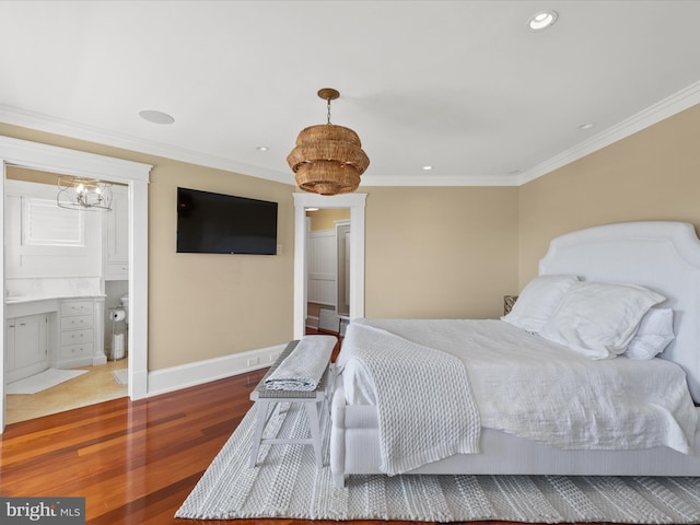 bedroom featuring ensuite bath, crown molding, and hardwood / wood-style floors