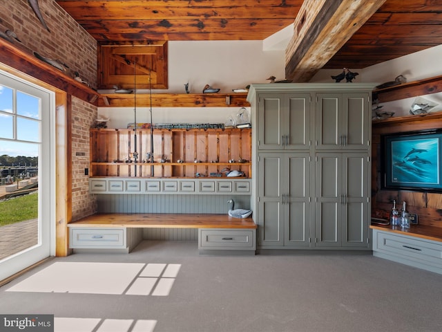 mudroom with carpet, wooden ceiling, and brick wall