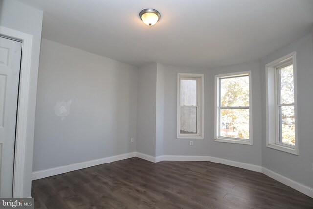 unfurnished room with dark wood-type flooring and plenty of natural light