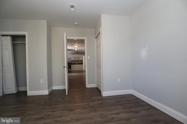 unfurnished bedroom with dark wood-type flooring