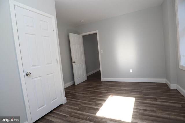 unfurnished room featuring dark wood-type flooring