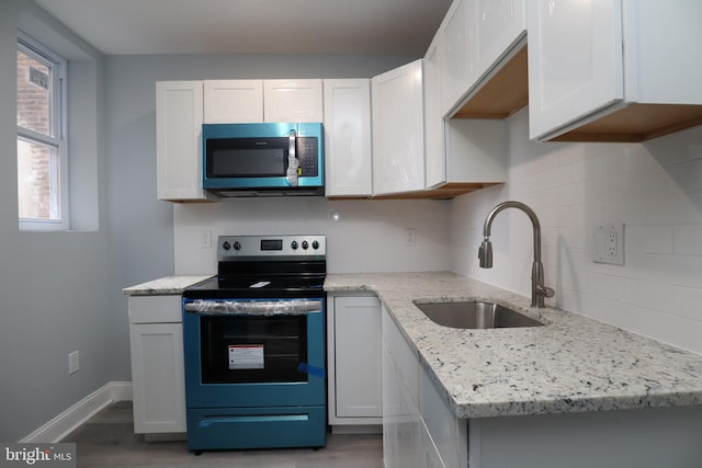 kitchen featuring a healthy amount of sunlight, stainless steel appliances, sink, and white cabinetry