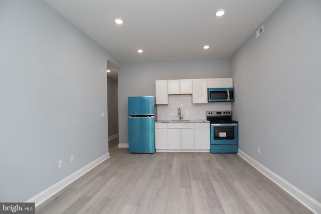 kitchen featuring backsplash, sink, appliances with stainless steel finishes, and light hardwood / wood-style floors