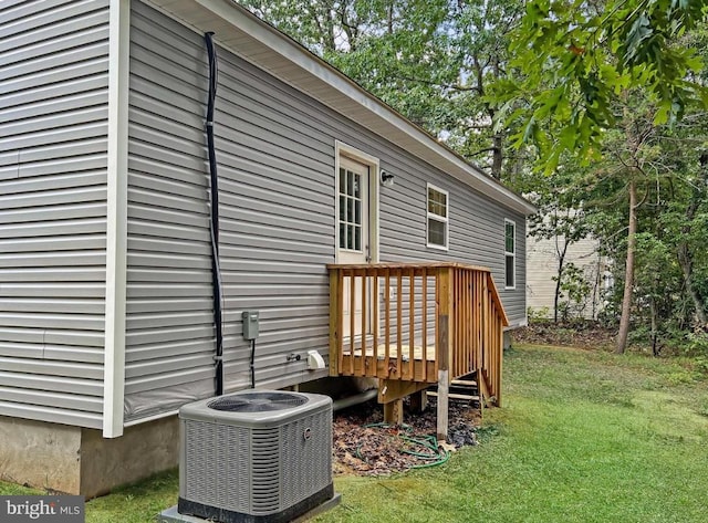 wooden terrace featuring central AC and a lawn