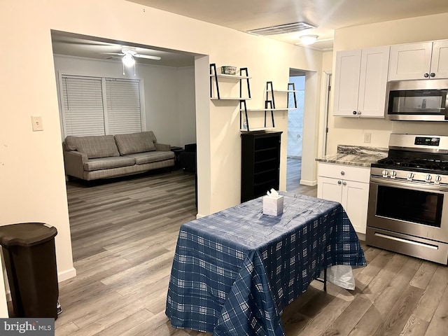 5601 Briarwood Dr, Millville, NJ 08332 - kitchen with appliances with stainless steel finishes, light wood-style floors, white cabinetry, and a ceiling fan
