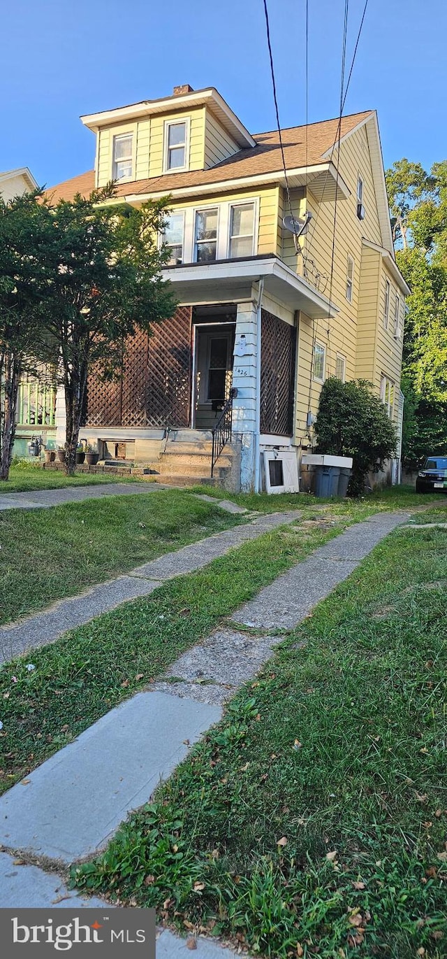 view of front of property with a porch and a front yard