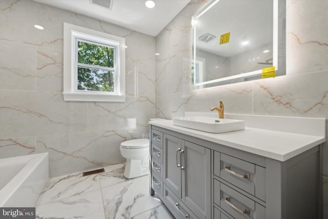 bathroom featuring tile walls, toilet, a washtub, and vanity