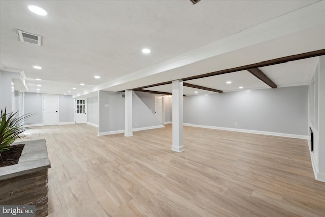 basement featuring light wood-type flooring and crown molding