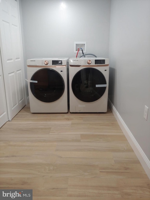 washroom featuring light hardwood / wood-style flooring and washer and dryer