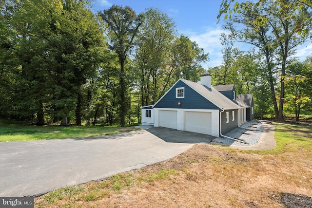 view of home's exterior with a garage and a lawn