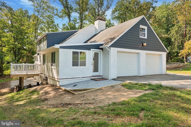 view of front of house with a garage, a front lawn, and a deck