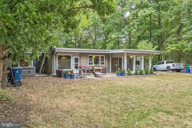 back of property featuring a lawn and a patio area