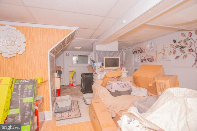 interior space with a paneled ceiling and hardwood / wood-style flooring