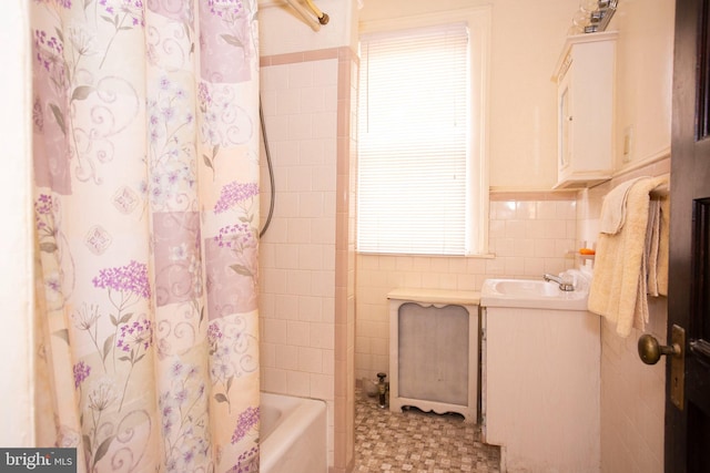 bathroom featuring vanity, tile walls, and shower / bath combo with shower curtain