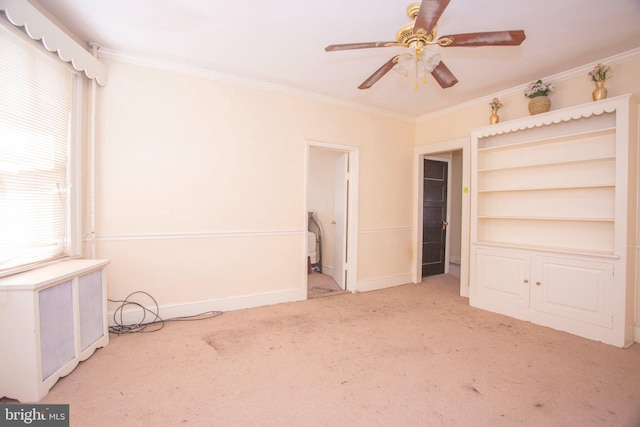 unfurnished bedroom featuring multiple windows, ceiling fan, crown molding, and light carpet