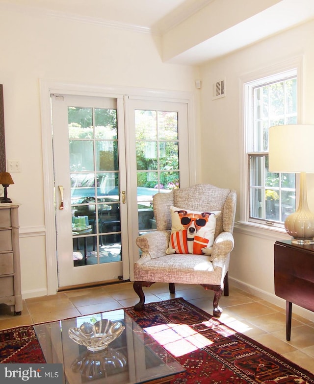 sitting room with ornamental molding, a wealth of natural light, and light tile patterned floors