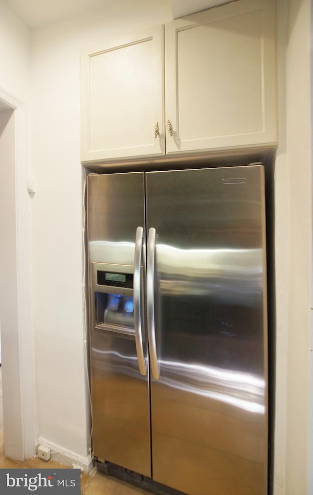 details featuring stainless steel fridge and white cabinetry