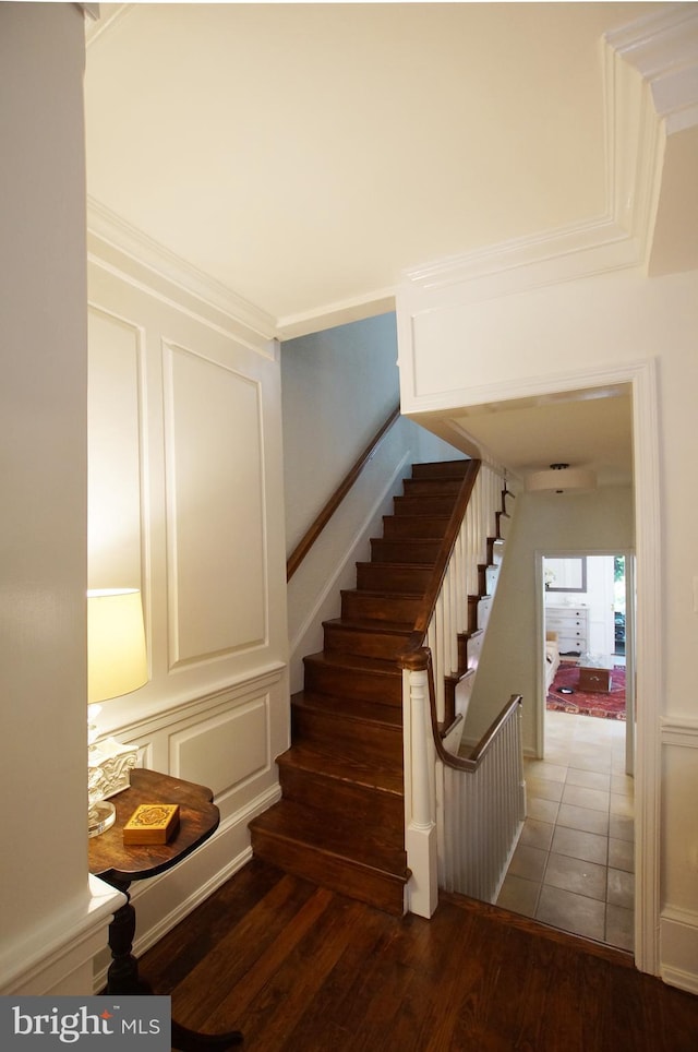 stairs with crown molding and hardwood / wood-style floors