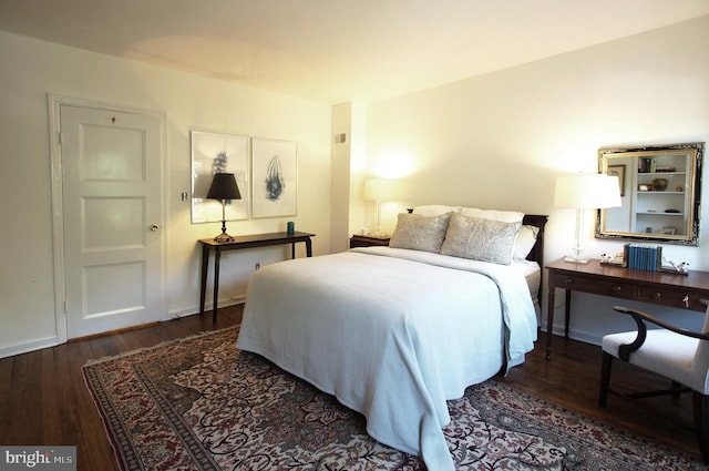 bedroom with dark hardwood / wood-style flooring