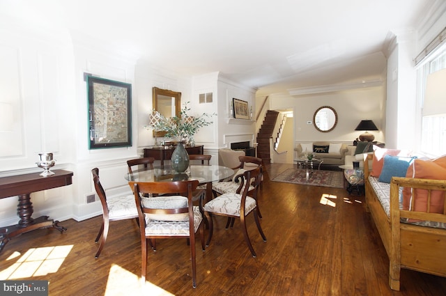 dining space with ornamental molding, wood-type flooring, and a wealth of natural light