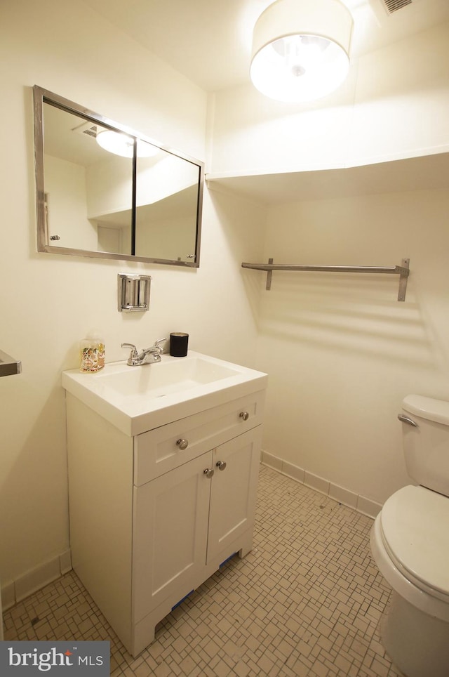 bathroom featuring tile patterned flooring, vanity, and toilet