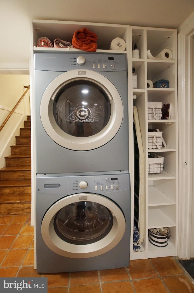 laundry area featuring tile patterned flooring and stacked washer and dryer