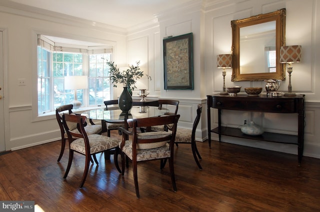 dining space featuring crown molding and dark hardwood / wood-style flooring