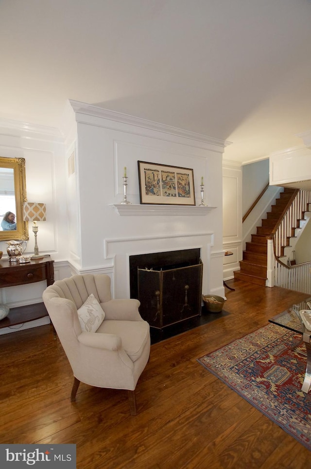 living room with dark hardwood / wood-style floors and crown molding