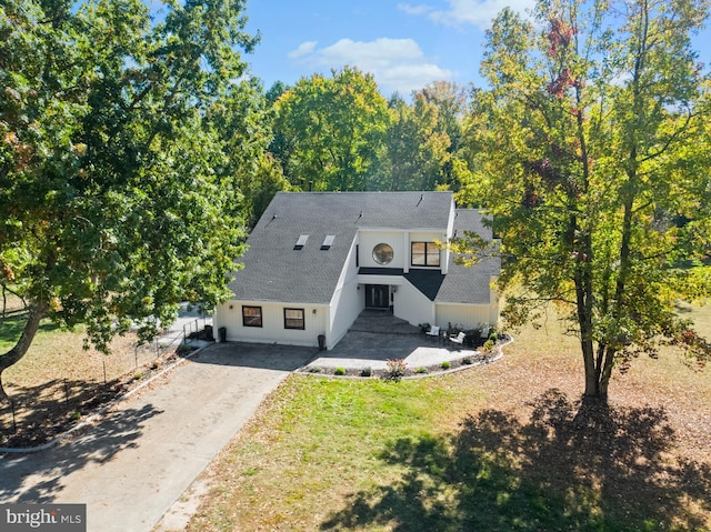 view of front of property with a front yard, driveway, fence, and a shingled roof