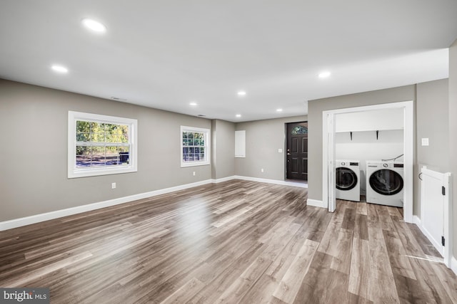 laundry area with baseboards, laundry area, recessed lighting, wood finished floors, and washing machine and clothes dryer