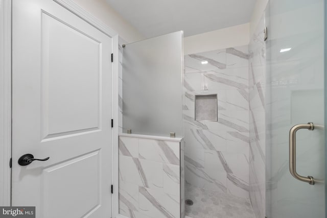 bathroom featuring a marble finish shower