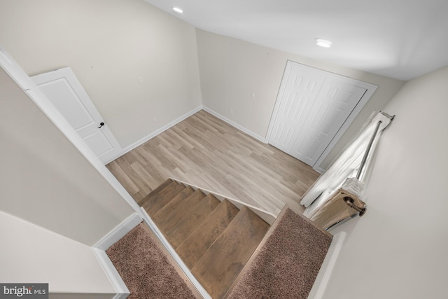 stairs with wood finished floors and baseboards