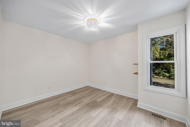 empty room featuring visible vents, baseboards, and light wood-style floors