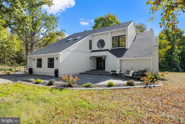 modern farmhouse featuring a patio and roof with shingles