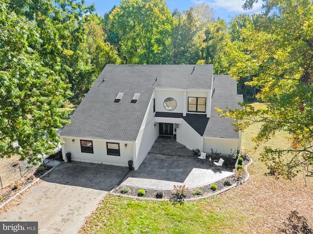 view of front of property with a shingled roof and a patio