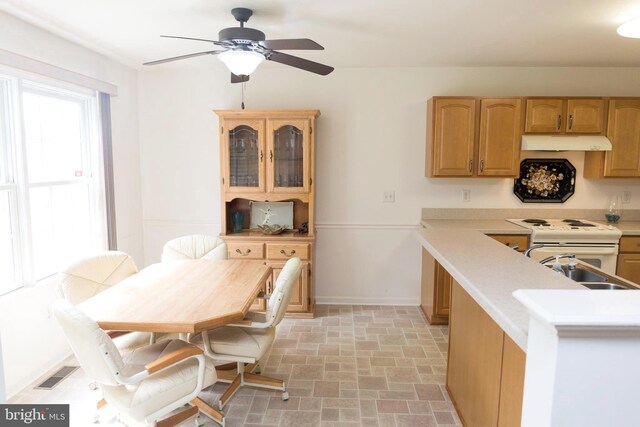 kitchen with ceiling fan, kitchen peninsula, sink, and white appliances