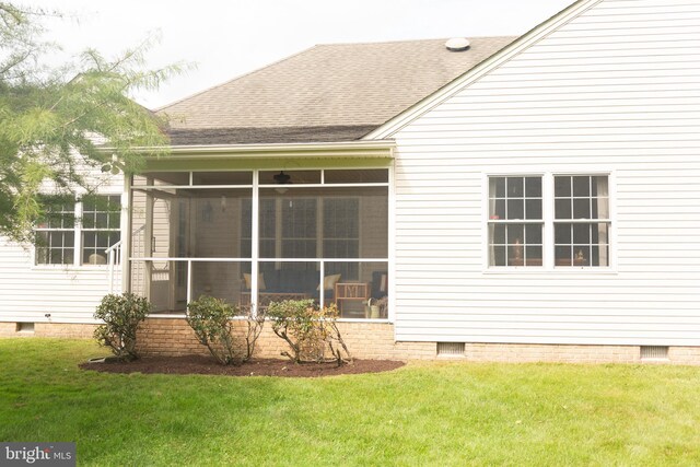 rear view of property featuring a yard and a sunroom