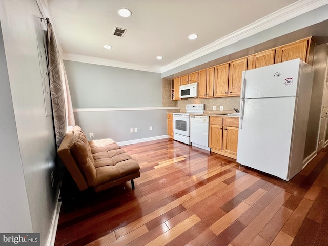 kitchen with tasteful backsplash, sink, white appliances, dark wood-type flooring, and ornamental molding