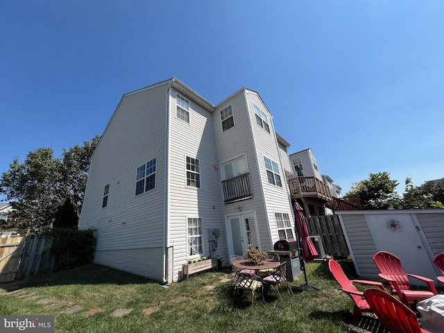 rear view of property featuring a yard, an outdoor fire pit, and a storage shed