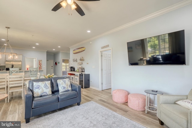 living room featuring ceiling fan, light hardwood / wood-style floors, and ornamental molding