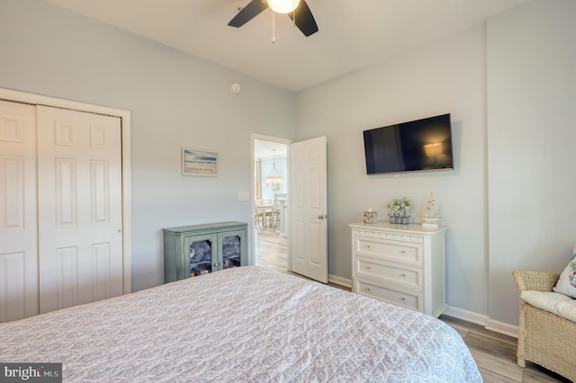 bedroom with light hardwood / wood-style flooring, ceiling fan, and a closet