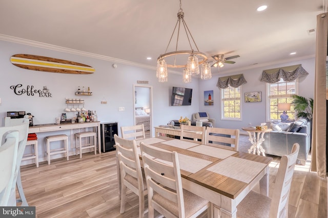 dining area featuring crown molding, light hardwood / wood-style flooring, ceiling fan, and beverage cooler