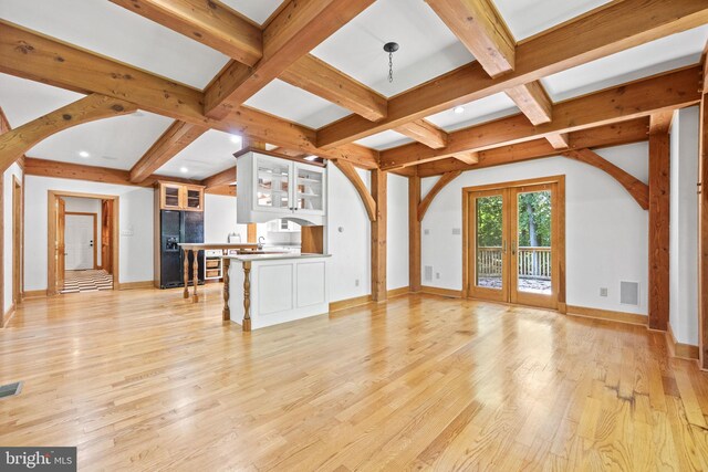 unfurnished living room featuring coffered ceiling, beam ceiling, and light hardwood / wood-style floors