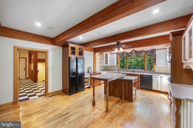 kitchen with a breakfast bar area, light hardwood / wood-style flooring, black appliances, a center island, and ceiling fan