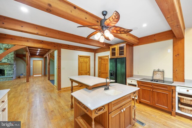 kitchen with a kitchen island with sink, black appliances, sink, ceiling fan, and light hardwood / wood-style floors