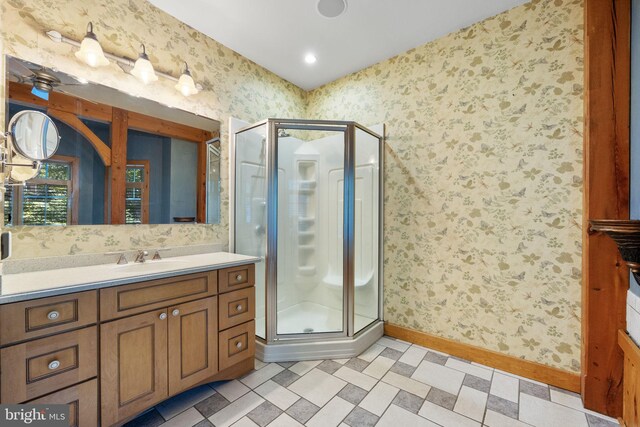 bathroom featuring a shower with door, vanity, and ceiling fan