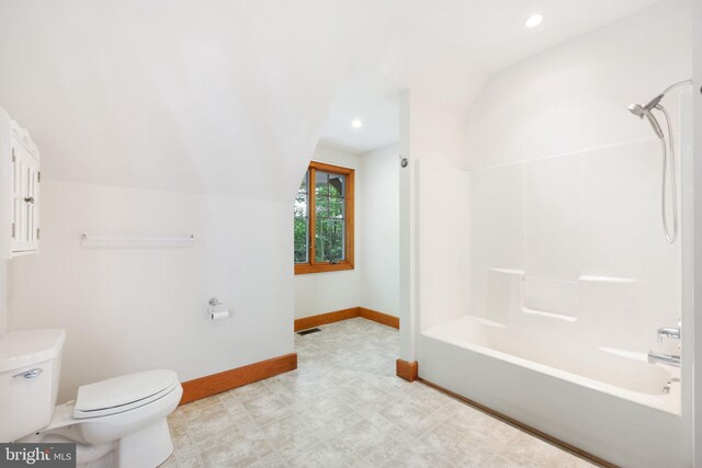 bathroom featuring lofted ceiling, toilet, and shower / bath combination