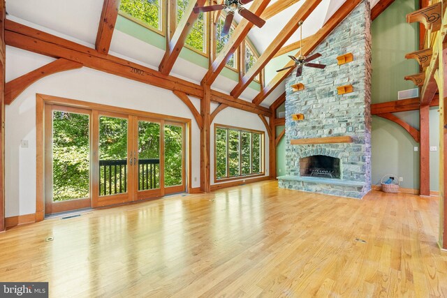 unfurnished living room with ceiling fan, a wealth of natural light, and a fireplace