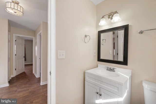 bathroom featuring vanity, hardwood / wood-style floors, and toilet