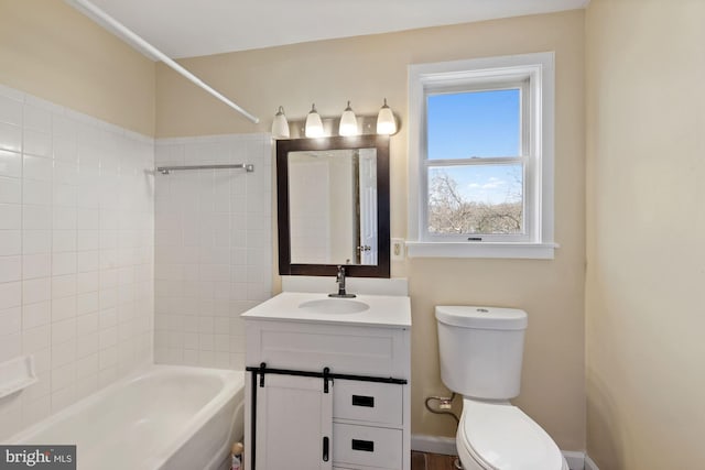 full bathroom with tiled shower / bath, plenty of natural light, vanity, and toilet